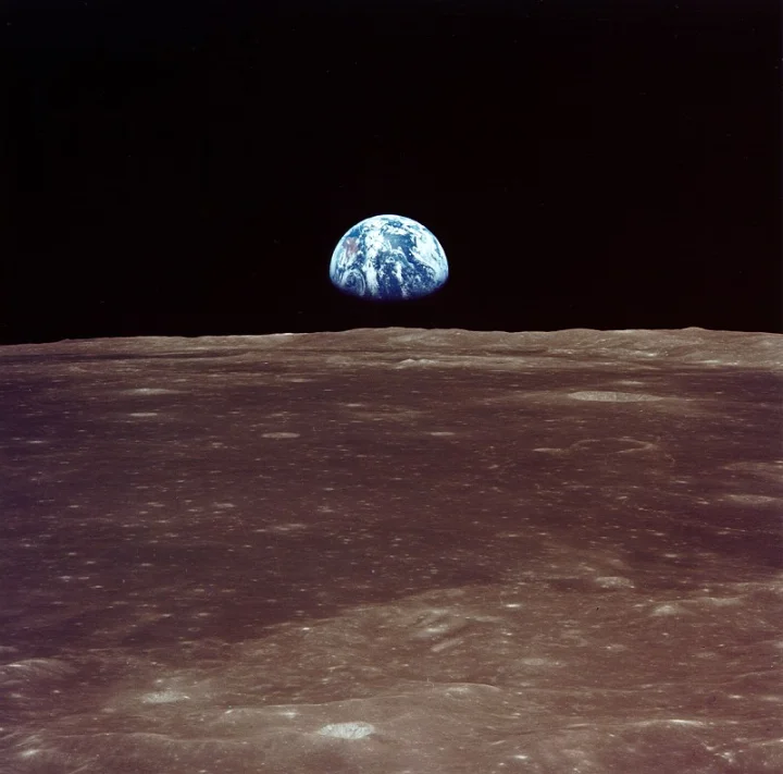 Earth above a cratered lunar horizon against the blackness of space.