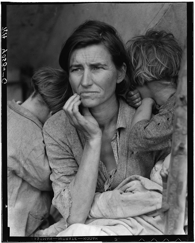 Florence Owens Thompson with a hand against her cheek, two children turned away and a baby in her lap.