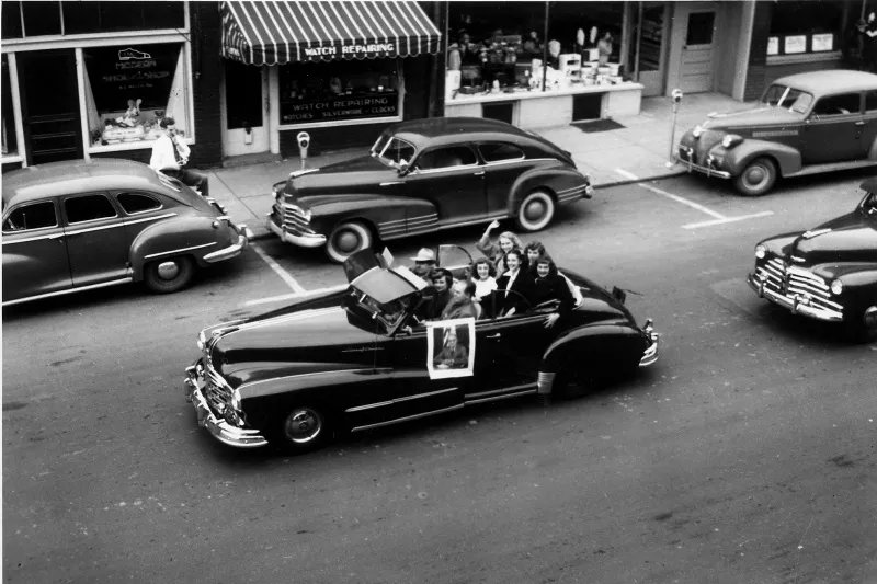 Young Truman supporters riding in an election parade car decorated with his portrait.