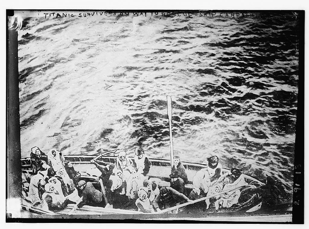 A lifeboat carrying Titanic survivors on the water towards the rescue ship Carpathia.