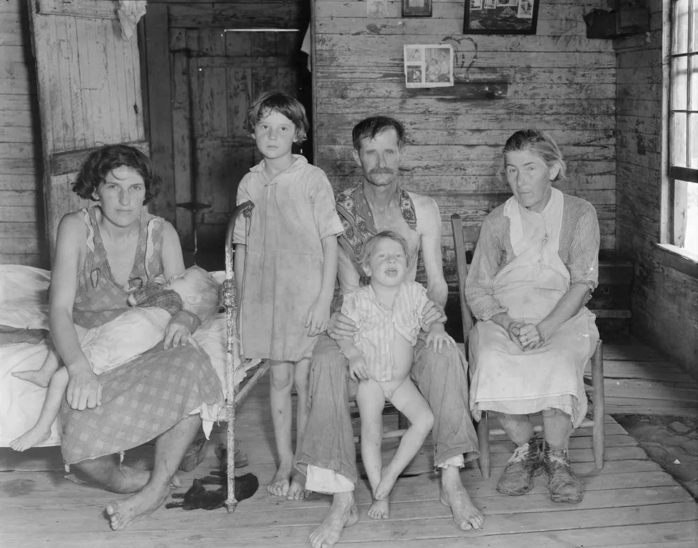 Bud Fields and his family sit and stand inside their Alabama home.