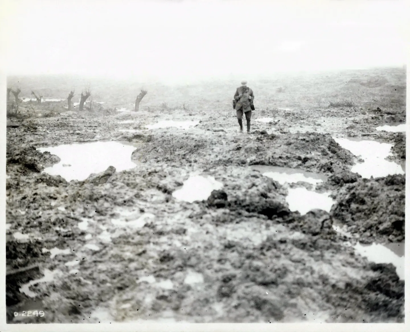 Water-filled shell holes, mud and barbed wire across a devastated battlefield.