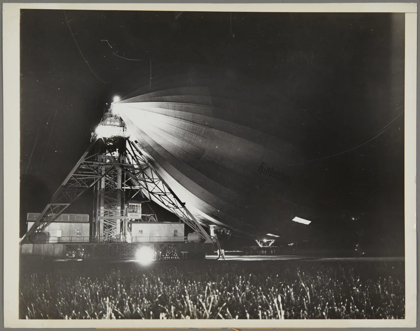 Hindenburg leaving Lakehurst, with people visible on the field beneath the airship.