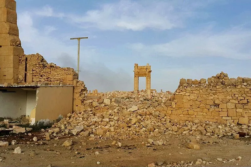 Collapsed masonry at the Temple of Bel in March 2016, with a surviving monumental gateway beyond the ruined walls.