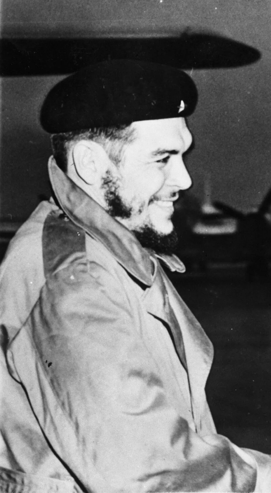 Archival press portrait of a bearded Che Guevara in military clothing.