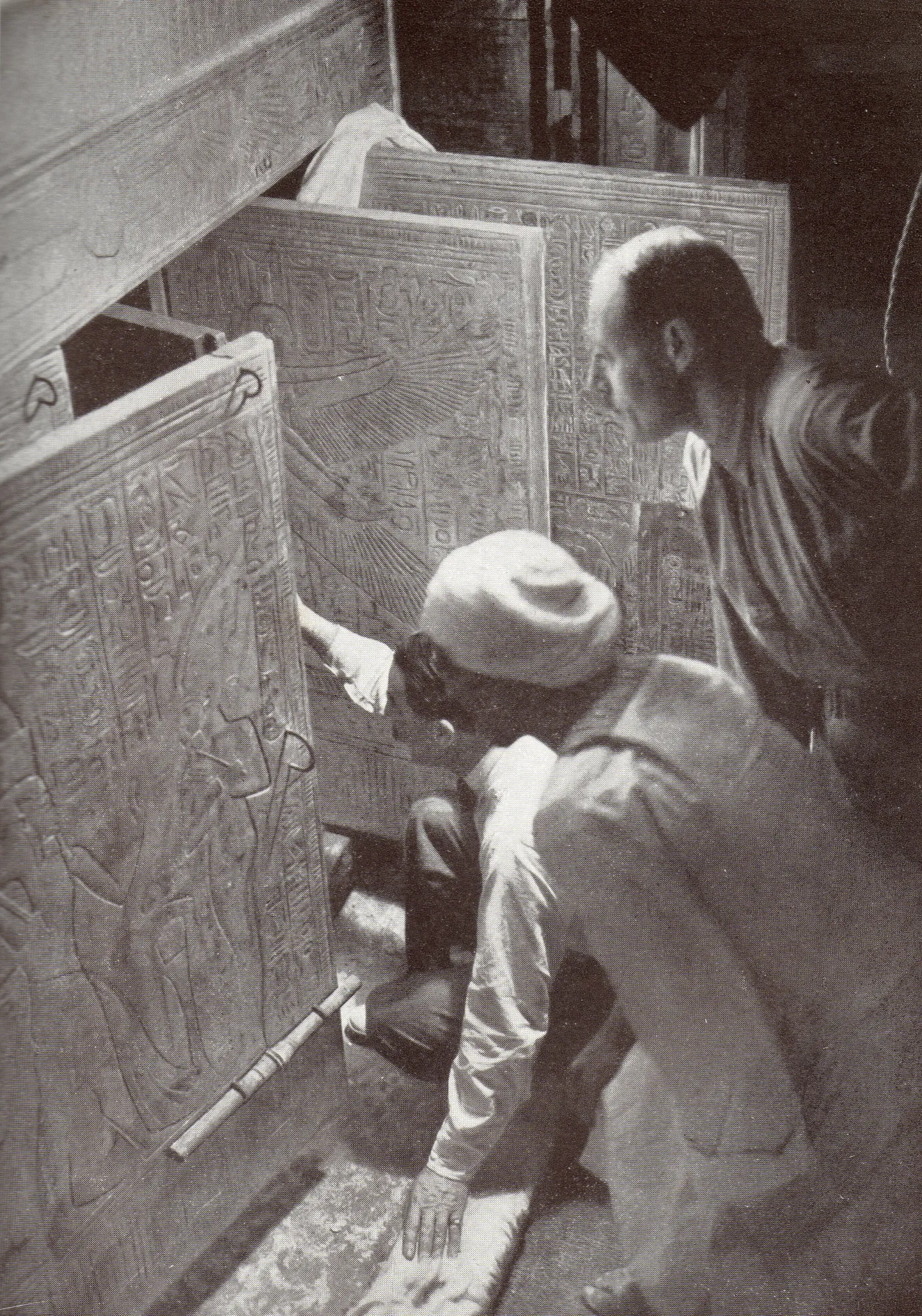 Carter kneeling beside decorated shrine doors with two colleagues.