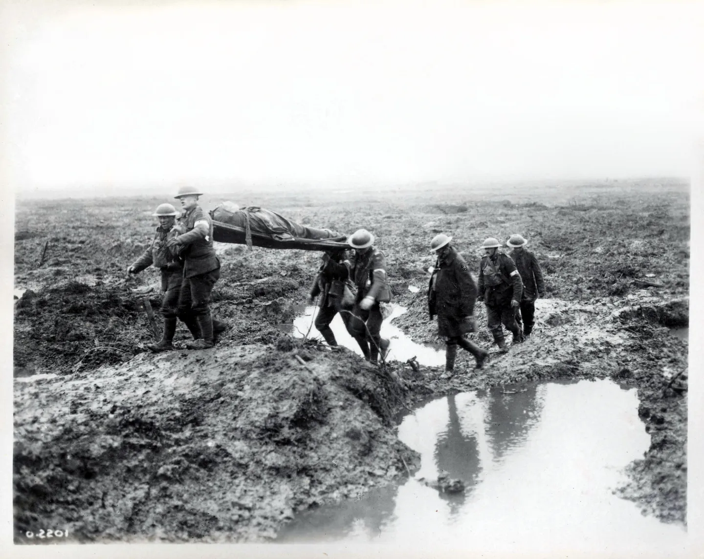 Wounded Canadian soldiers moving along a muddy path toward an aid post.