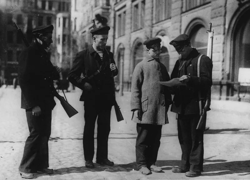 Armed Red Guards inspect a man’s papers on a Petrograd street.