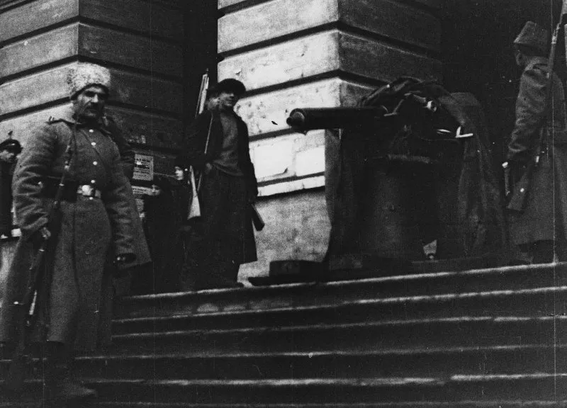 Armed guards and a machine gun stand on the steps at the Smolny entrance.