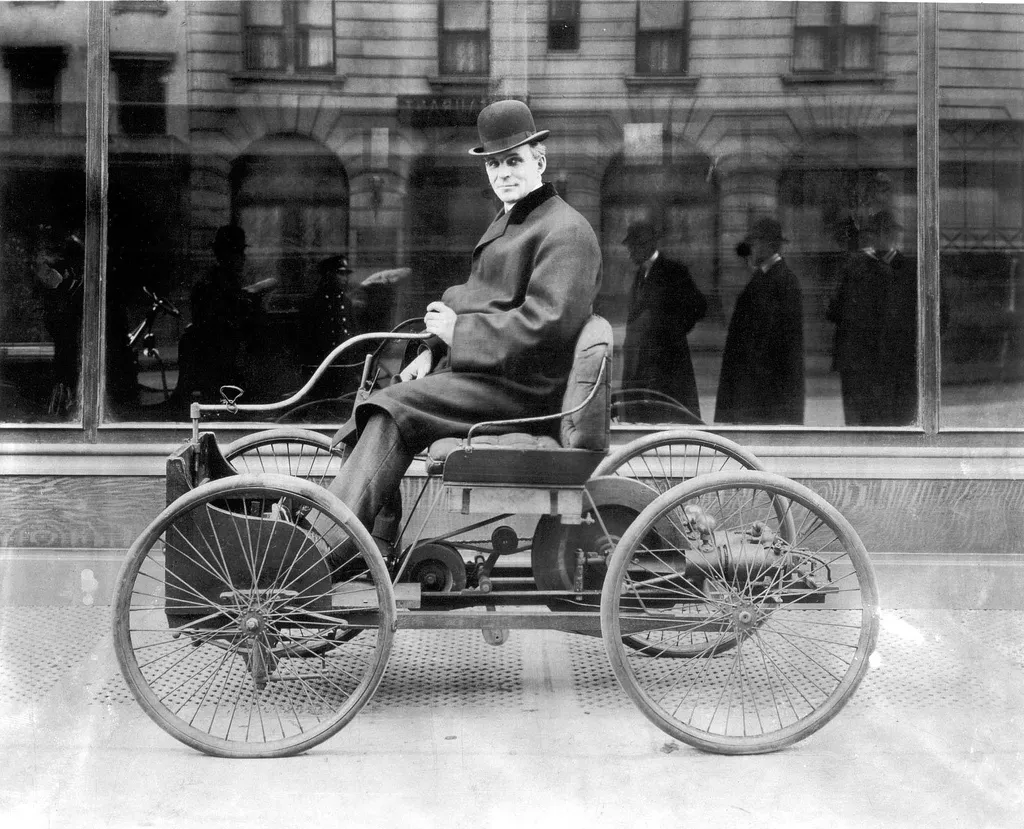 Henry Ford seated in his Quadricycle on a city street.