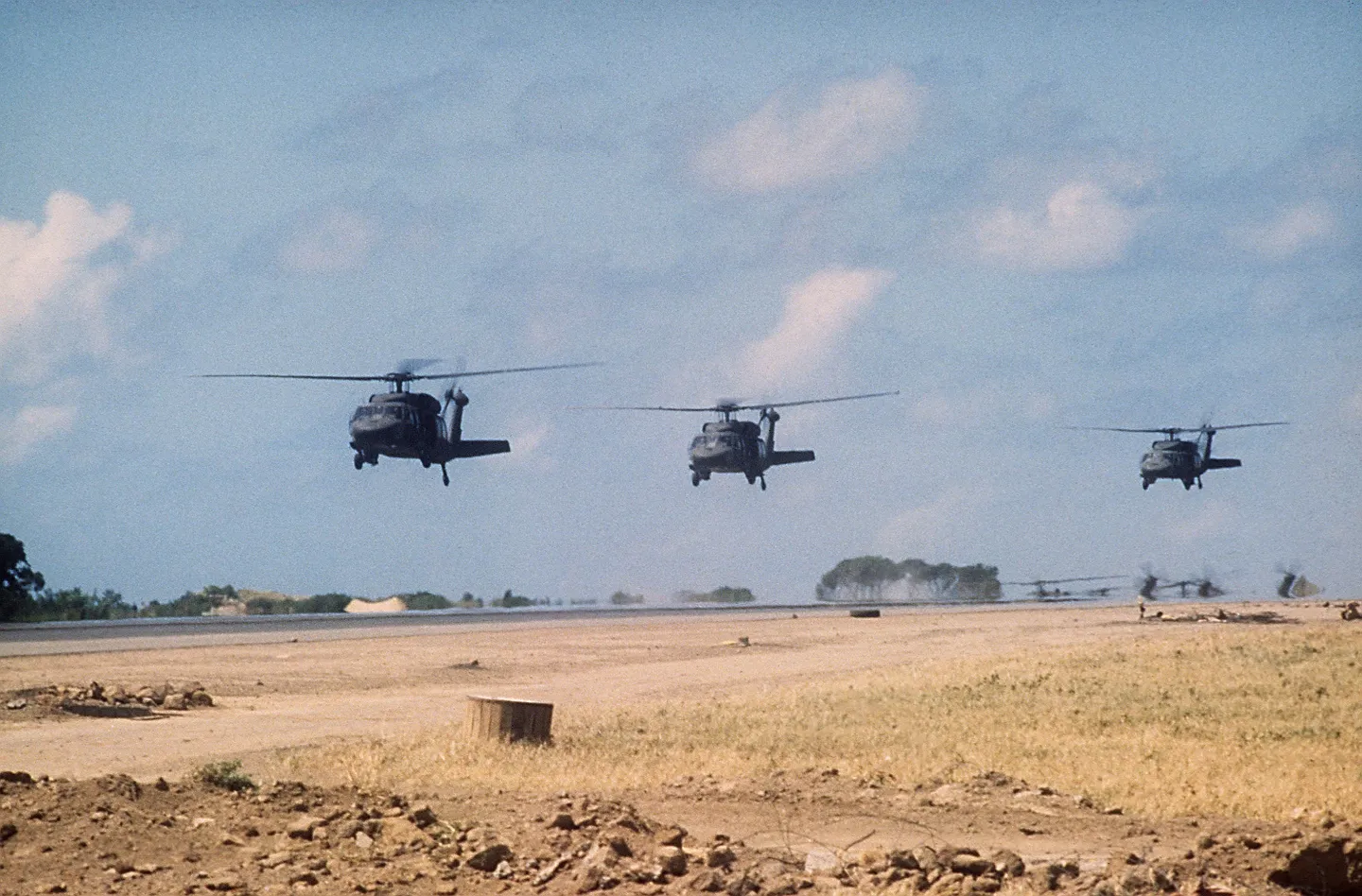 U.S. Army Black Hawk helicopters flying low toward the Point Salines Airport runway during Operation Urgent Fury