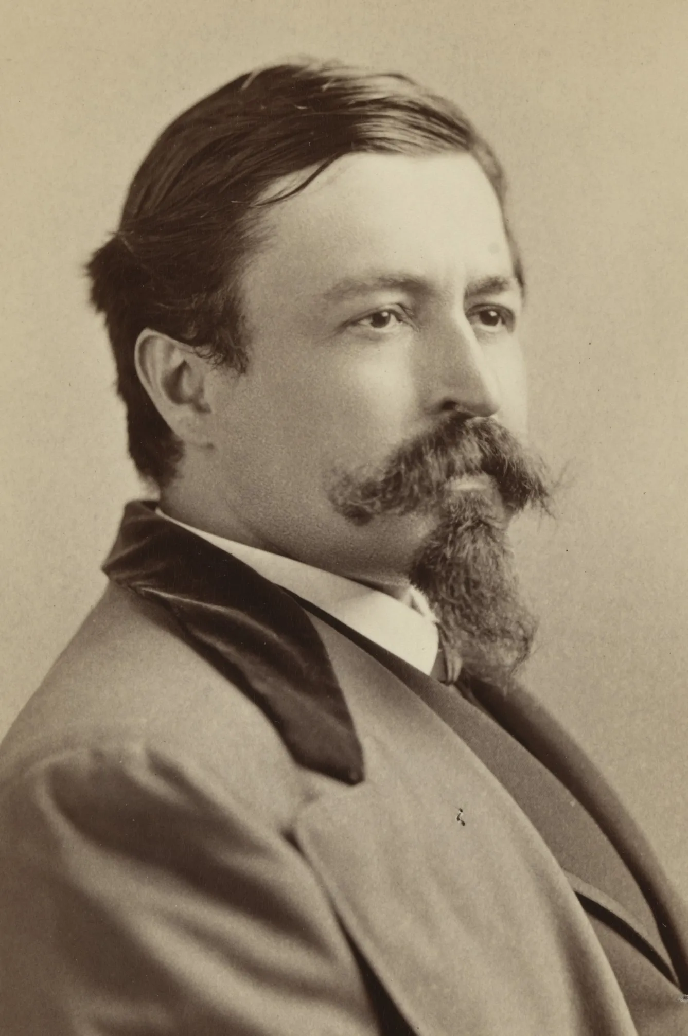 Thomas Nast poses in a dark suit in a studio portrait.