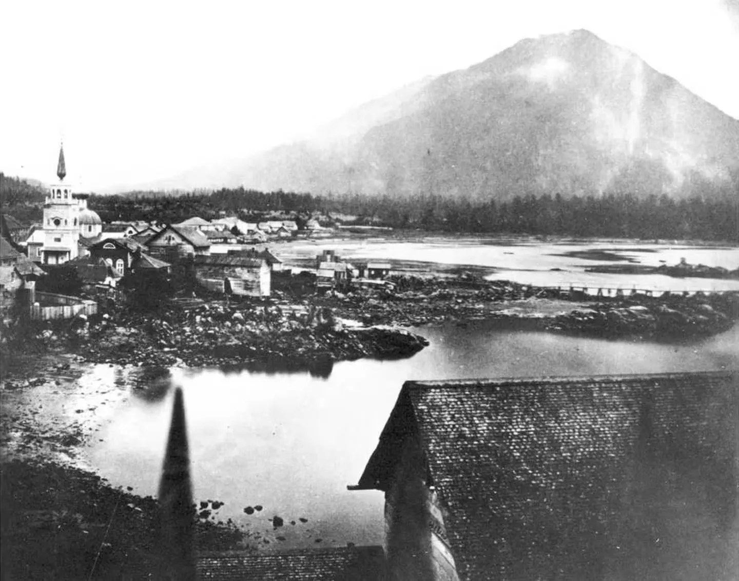 An 1868 view of Sitka from the Governor’s Garden, with St. Michael’s Cathedral and a mountain behind the town.