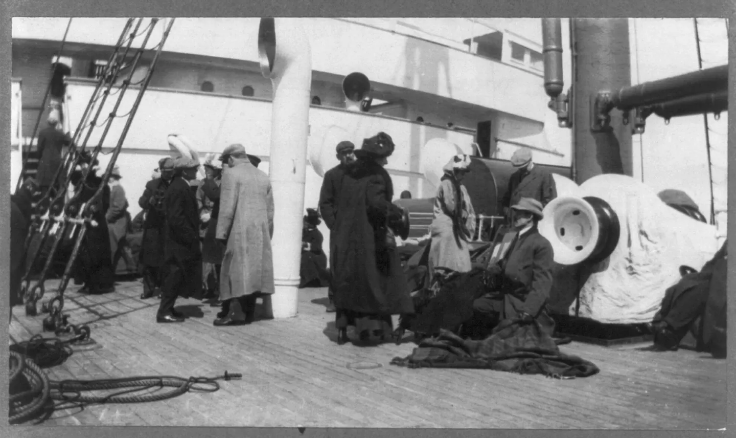 An unidentified group of Titanic survivors gathered on Carpathia’s deck beside ropes and deck fittings.