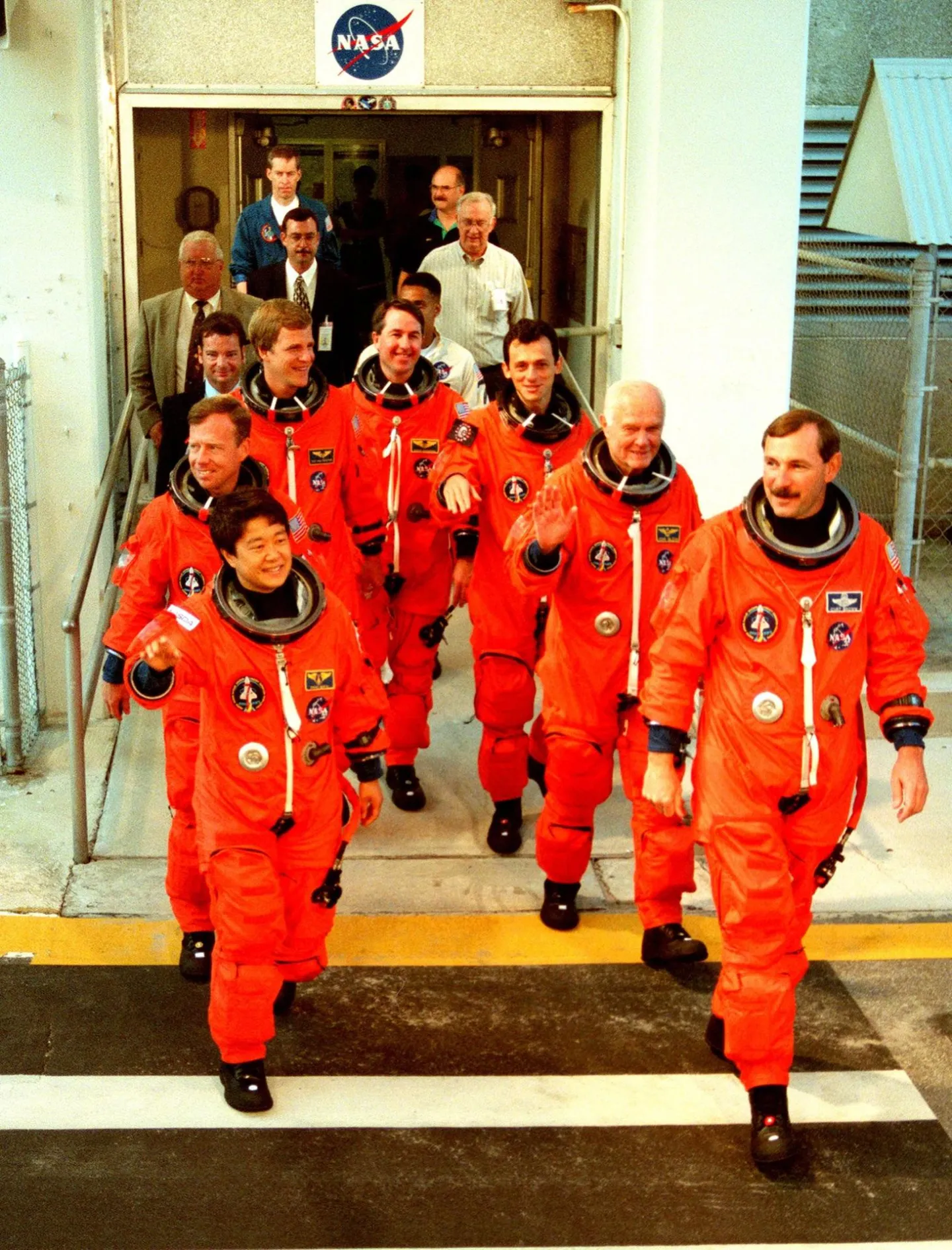 STS-95 astronauts leave a Kennedy Space Center building during a countdown rehearsal.