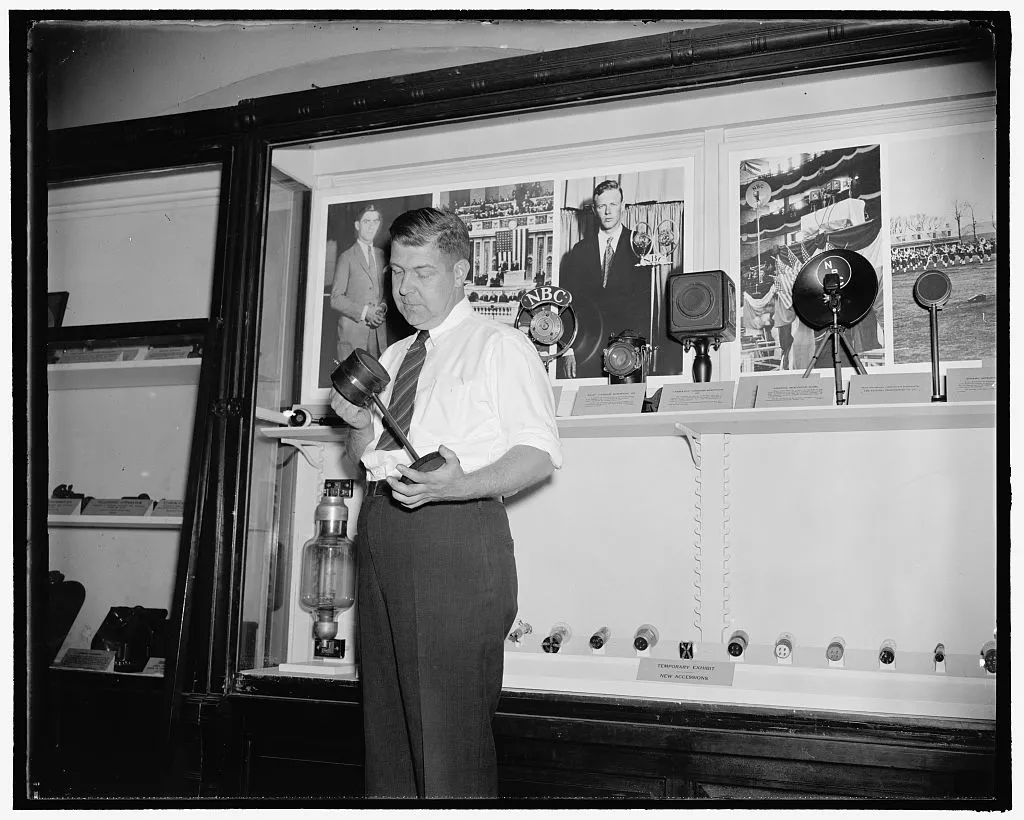 Smithsonian aide Fred C. Reed with the microphone associated with the 1920 broadcast.