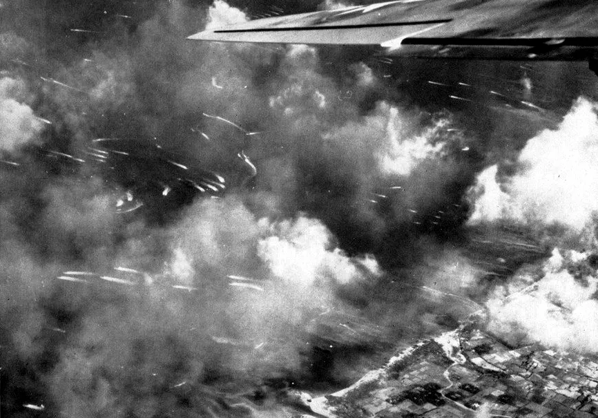 Landing craft and their white wakes seen from an aircraft through clouds off the Leyte coast.