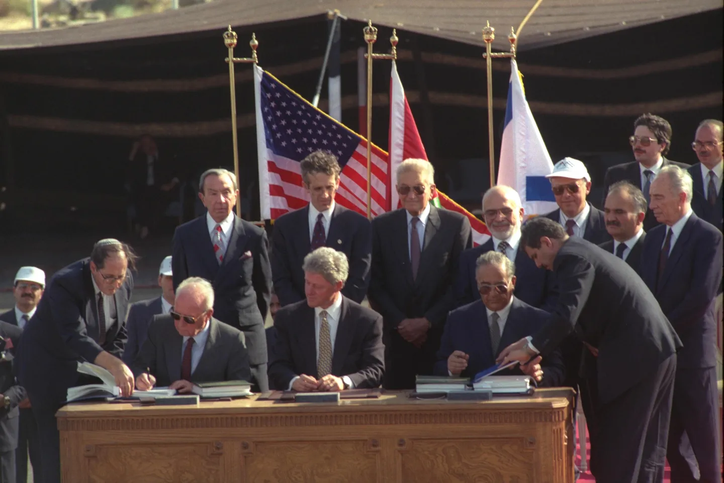 Yitzhak Rabin and Abdelsalam al-Majali signing the Israel–Jordan peace treaty in the presence of Bill Clinton.